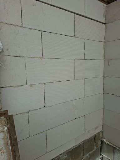 Eine graue Blockwand mit glatten Oberflächen und rechteckigen Blöcken.